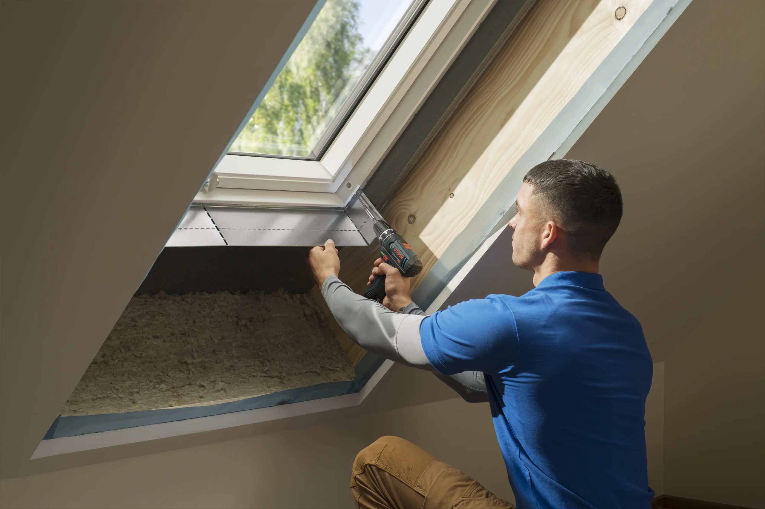 Ein Fachmann nimmt an einem Dachfenster eine Reparatur der Innenverkleidung in Würzburg vor.